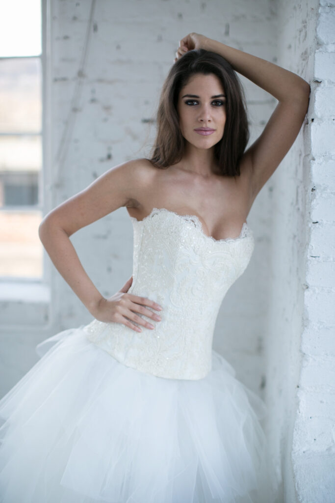 A Zhoja Bridal Romantic kollekciójának főképe. Kézműves részletekkel hímzett, pánt nélküli csipke fűző és többrétegű hercegnős tüll szoknya, amely egyedi méretre készül a szalonban.