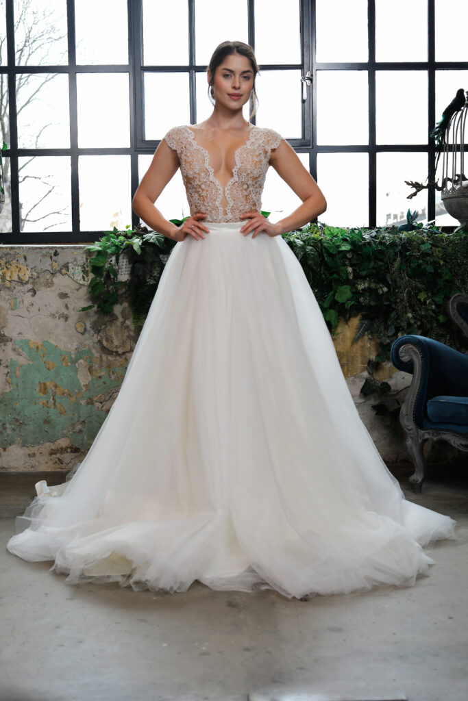 A Zhoja Bridal Roses kollekciójának főképe. Extravagáns és nőies esküvői ruha áttetsző illúzió tüll alapon finom csipke rátétekkel és hercegnős tüll szoknyával, egyedileg méretre szabva.