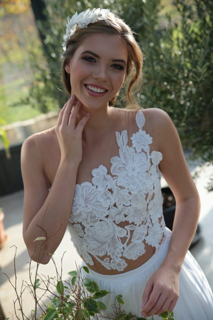 A Zhoja Bridal Vintage kollekciójának főképe. Aprólékos kézi munkával felvitt virágmintás csipke rátétekkel díszített illúzió tüll felsőrész és könnyed szoknya, egyedileg méretre szabva a szalonban.