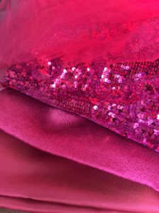 Fukszia és magenta színű luxus textilek, finom tüll, flitteres csipke és selymes szatén egymásra rétegezve.